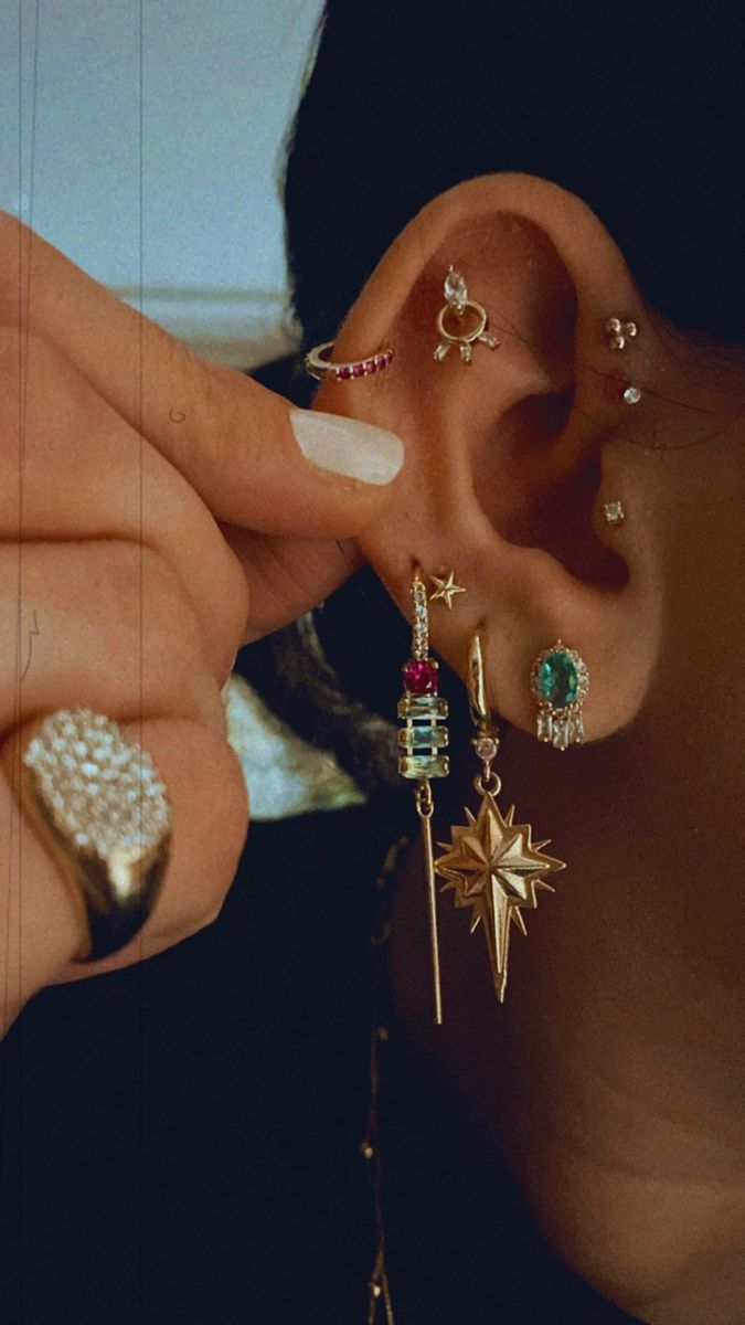 a close up of a person with ear piercings on their ears and one hand