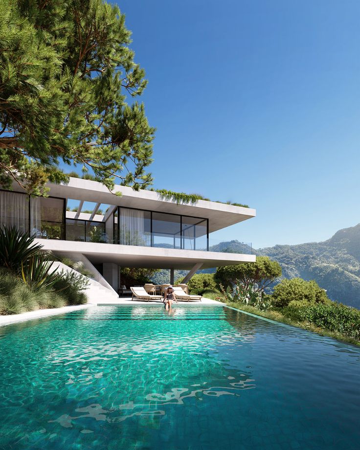 a house with a pool in front of it and some trees around the pool area