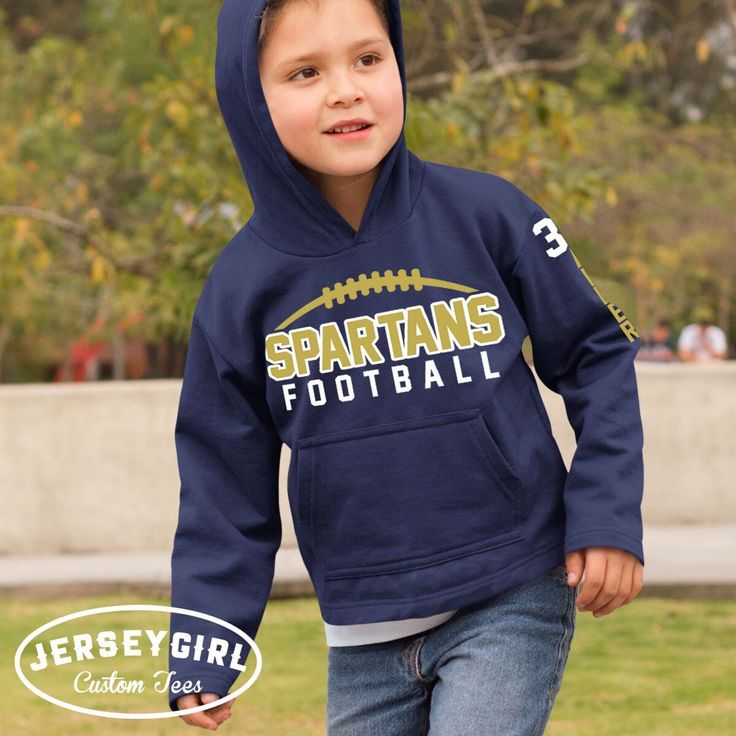 a young boy wearing a sweatshirt with the words spartans football on it