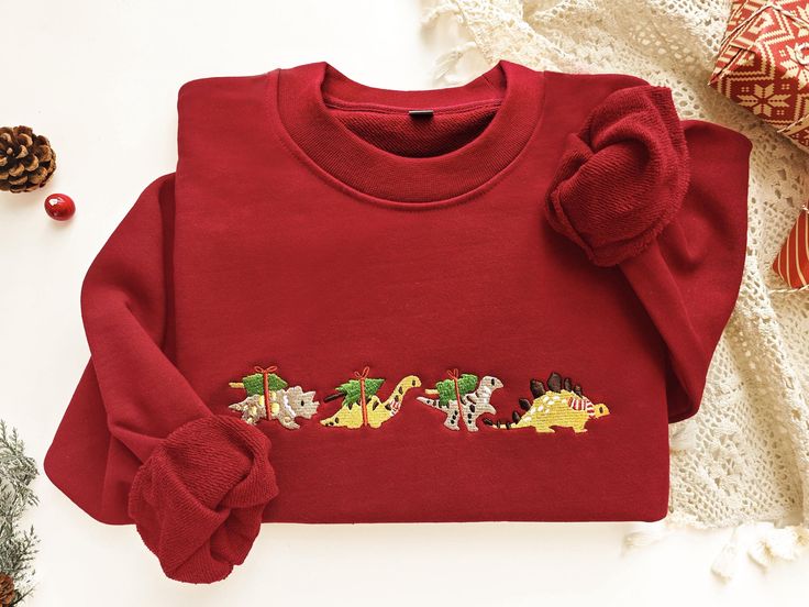 This sweatshirt is made of high quality cotton weave, advanced embroidery technology to ensure bright colors and detailed patterns, unisex and soft and comfortable. Sweatshirt makes for an edgy, casual style. Each sweatshirt has a unique aesthetic, and is a gift that will not go out of style for your own family, friends, or teachers. Size We offer a variety of colors and different sizes, you can choose your favorite and size, we recommend that you use the size of the potential better fit or loose size, if you like a tight fit can be selected according to the size, if you have any special requirements, please give me a message! Maintenance Wash from inside to outside with cold water and dry with a low-speed tumble dryer. Please do not dry clean. Do not rub the embroidery pattern with force. Dinosaur Crewneck, Floral Dinosaur Sweater, Dino Christmas Shirt, Unisex Dinosaur Print Crew Neck Top, Edgy Casual Style, Dinosaur Christmas Sweater, Christmas Dinosaur, Advanced Embroidery, Dinosaur Shirt