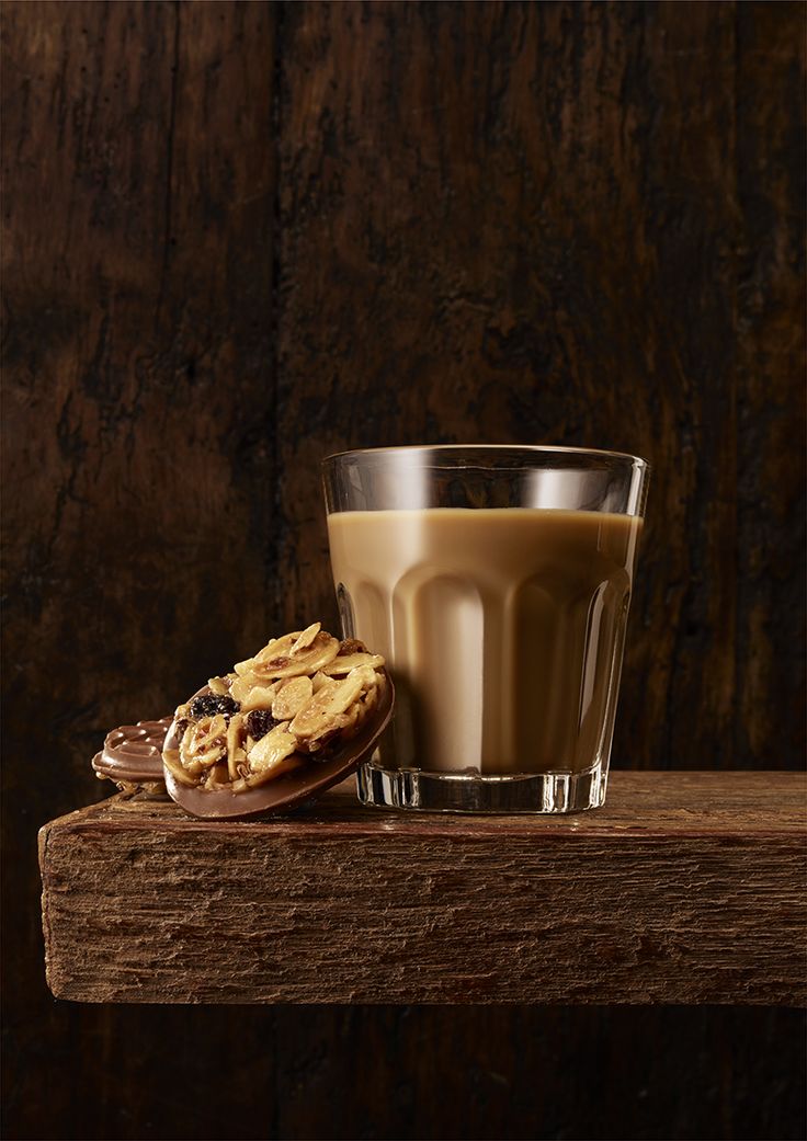 a cookie and glass of milk on a wooden table