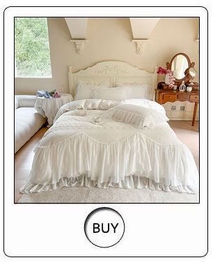 a white bed with ruffled bedspread and pillows