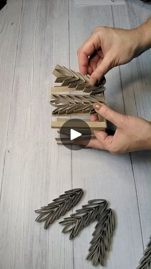 someone is making some decorative items out of wood and metal leaves on the table with their hands