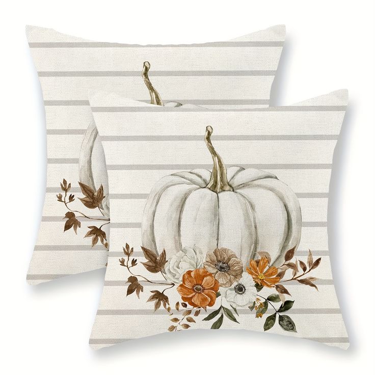 two white pumpkins and flowers on striped pillows