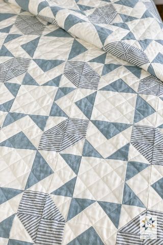 a blue and white quilt on top of a bed