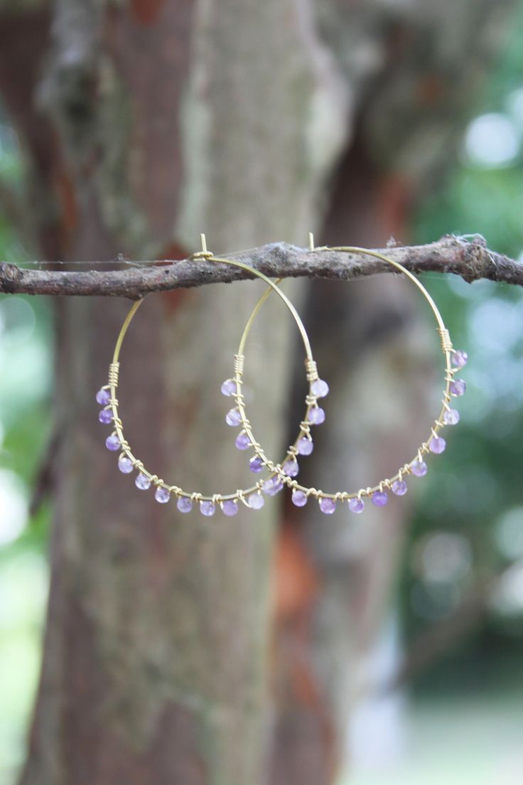 "earrings, dangle earrings, trendy jewelry, boho jewelry, beaded hoops, hoop earrings, bronze hoops, seed bead hoops These raw brass hoop earrings have been wrapped with tiny faceted amethyst beads, the hoops measure 1.5\" in diameter." Bohemian Hand Wrapped Hoop Earrings, Bohemian Wire Wrapped Dangle Hoop Earrings, Bohemian Style Wire Wrapped Dangle Hoop Earrings, Purple Dangle Hoop Earrings With Ear Wire, Purple Bohemian Round Hoop Earrings, Bohemian Purple Round Hoop Earrings, Handmade Purple Dangle Hoop Earrings, Purple Bohemian Hoop Earrings, Bohemian Purple Hoop Earrings