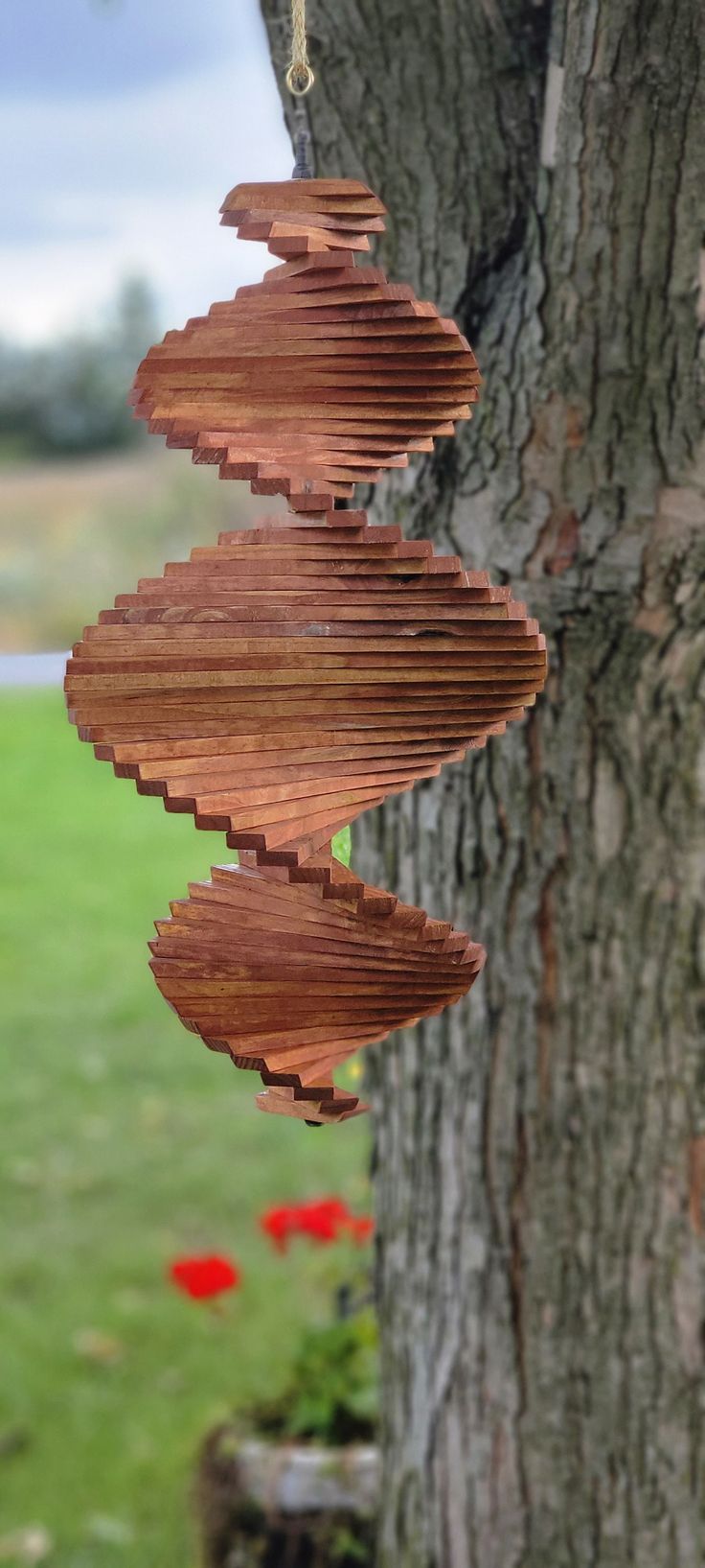 a wind chime hanging from the side of a tree