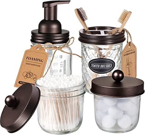 three jars with toothbrushes, soap dispenser and other items