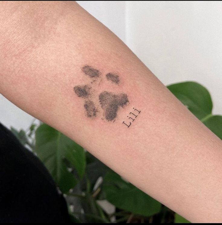 a person with a tattoo on their arm that has a dog's paw print