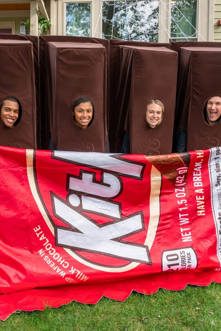 some people are smiling and sitting in front of a banner with chocolates on it