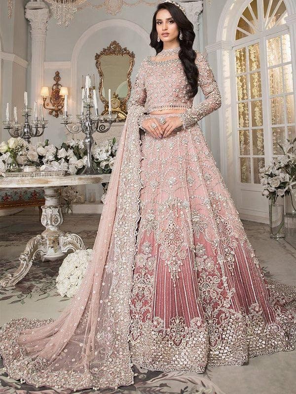 a woman in a pink lehenga with white flowers on the floor and chandelier