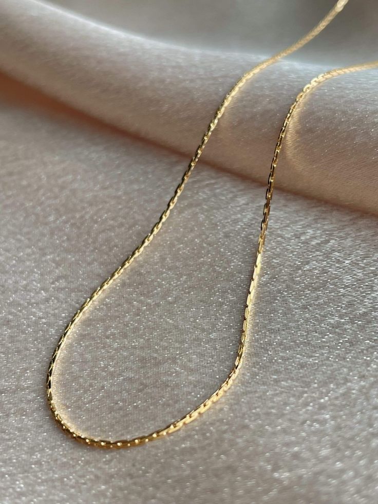 Your ultimate versatile queen, Audrey is minimal and reflective and will be the anchor of any look! The low profile and high shine of this chain gives Audrey the most dainty and delicate vibes of all of our chains. Understated and elegant on their own and an absolute essential in any layered necklace look, you can't go wrong with Serendipity chains! ........................... NECKLACE SIZE & MATERIAL❋ 17" chain with a 2" extender❋ 14k gold plated brass❋ nickel free Dainty Link Chain Necklace With Clavicle Chain, Minimalist Tarnish Resistant Snake Chain Necklace, Dainty Link Chain Necklace For Everyday, Everyday Dainty Link Chain Necklace, Minimalist Clavicle Chain Necklace, Chic 14k Gold Chain Necklace With Delicate Chain, Delicate Clavicle Chain Link Necklace, Minimalist Clavicle Chain Link Necklace, Timeless Cable Chain Necklace As Gift