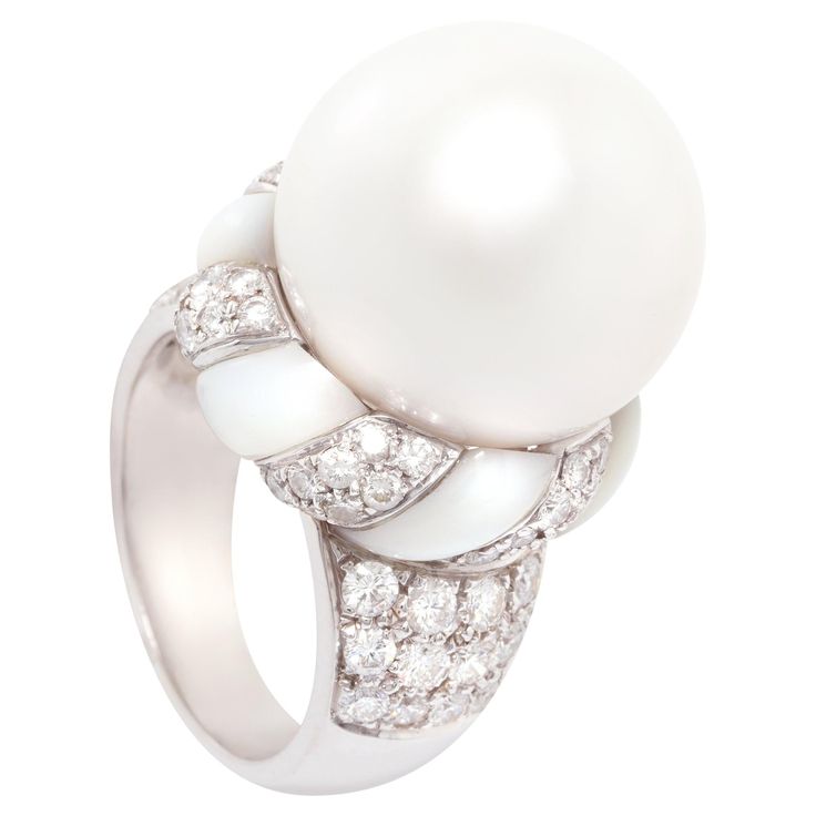 This South Sea pearl and diamond ring features a pearl of 16.5/17mm diameter. The pearl is untreated. It displays a splendid nacre and its natural color and luster have not been enhanced in any way. The pearl is perched on a crown of round diamonds with a mother-of-pearl ribbon, lending the jewel a distinctive art déco look. The total weight of diamonds is 1.54 carats. All diamonds are of top quality (F/G-VVS). The ring is one-of-a-kind. It was handmade in Italy by gran maestro Pasquale according to an original design by Ella Gafter. It features craftsmanship of the highest refinement. The item is signed EG. White Mother Of Pearl Wedding Ring, Elegant Round Mother Of Pearl Ring, Luxury White Rings With Pearl Drop, Luxury Mother Of Pearl Wedding Ring, Luxury Mother Of Pearl Rings For Wedding, Elegant White Mother Of Pearl Ring, White Mother Of Pearl Round Pearl Ring, Elegant Mother Of Pearl Round Rings, Luxury Pearl White Pearl Ring With Diamond Accents