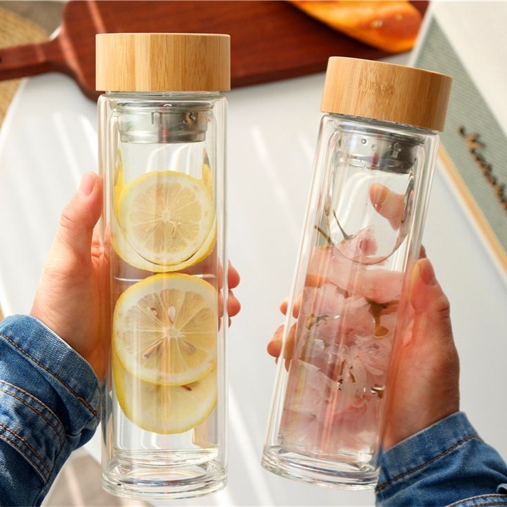 two people holding lemons and water in their hands