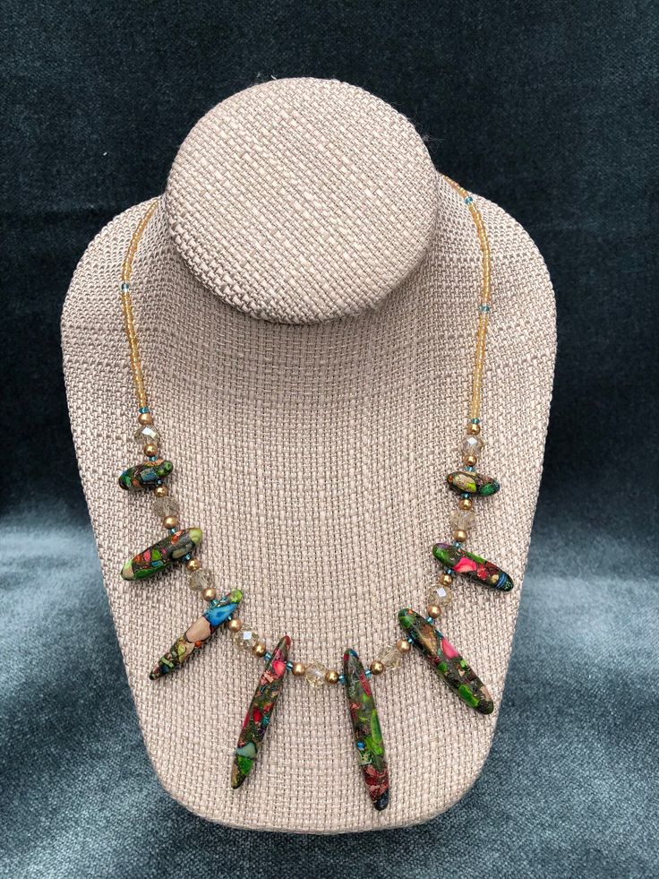 This womens beaded necklace is a little bit of sparkle, a little bit of shimmer, and a pop of vivid color from eight gorgeous mosaic beads ranging in size from 18mm to 45mm. The blue, green, red, and purple shades used to create these unique mosaic beads make a stunning statement in this one of a kind necklace design. Not only does the beauty of these beads stand out on their own in this necklace, but they work exquisitely to bring out the eye catching iridescent colors of the  gold pearlized se Multicolor Crystal Necklace With Beaded Chain For Parties, Unique Beaded Chain Necklaces For Festive Occasions, Adjustable Beaded Chain Necklaces For Festive Occasions, Adjustable Beaded Necklaces For Festive Occasions, Multicolor Faceted Beads Dangle Necklaces, Multicolor Dangle Necklaces With Faceted Beads, Adjustable Beaded Necklace With Czech Glass Dangling Beads, Adjustable Czech Glass Necklaces With Dangling Beads, Festive Adjustable Beaded Necklaces With Faceted Beads