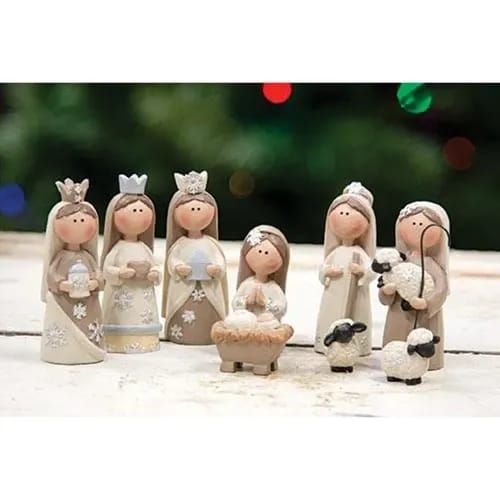 a group of little figurines that are standing on a table next to a christmas tree