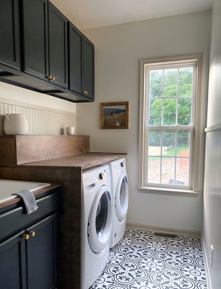 a washer and dryer in a small room with black cabinets on the walls