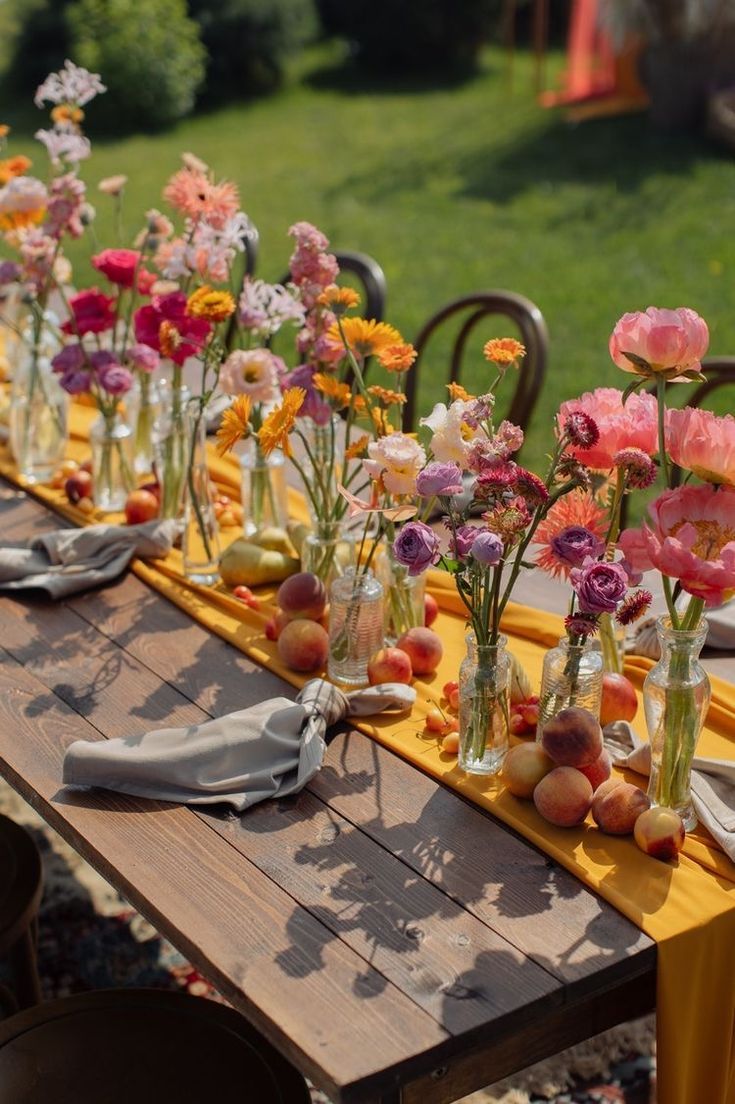 a long table with many vases filled with flowers