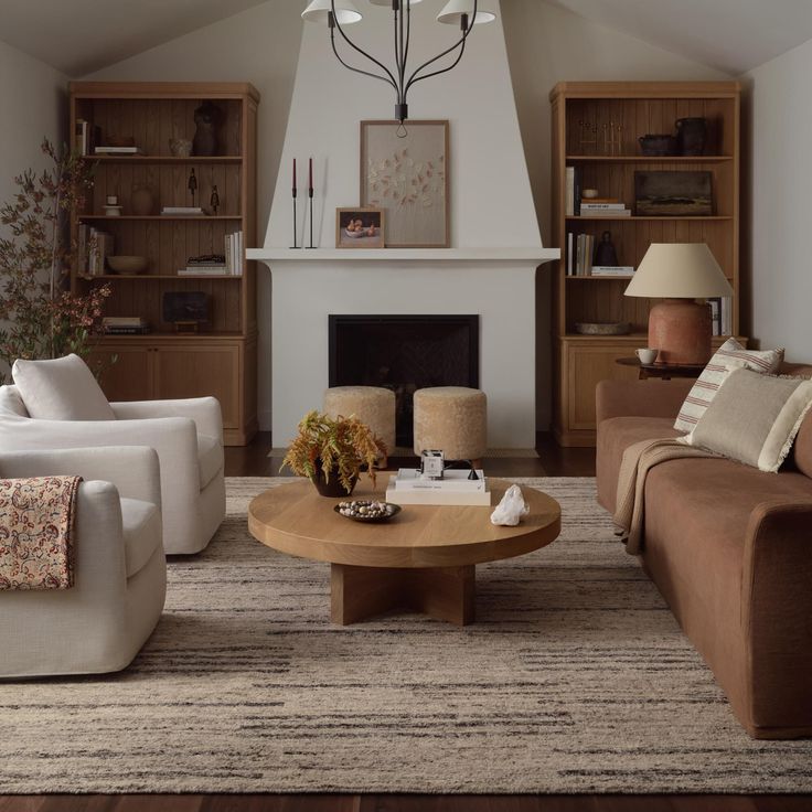 a living room with two couches and a coffee table in front of a fireplace