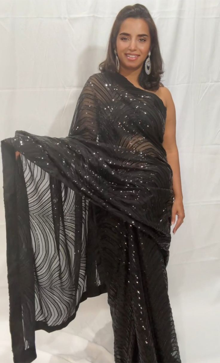 Dazzel like a star in this beautiful party perfect mesmerizing Georgette net saree where elegance meets charm.. Color - Available in 3 colors Black Wine Midnight Blue Fabric - Magnificent and soft ,elegant net made of Georgette Technique - An interplay of fabric and sequin creating a drape that delicately scintillates and transforms in movement and light. The saree is ready to wear with falls, pico and piping finished in finesse , and unstitched blouse fabric is included. Note: Colors that show Organza Pre-draped Saree For Diwali Evening, Traditional Organza Pre-draped Saree For Party, Glamorous Festive Pre-draped Saree With Sheer Dupatta, Glamorous Sequined Pre-draped Saree For Festivals, Bollywood Style Festive Pre-draped Saree With Sequins, Party Wear Pre-draped Sequined Saree For Festivals, Festive Pre-draped Saree For Party Season, Black Sequined Pre-draped Saree, Bollywood Georgette Pre-draped Saree For Party