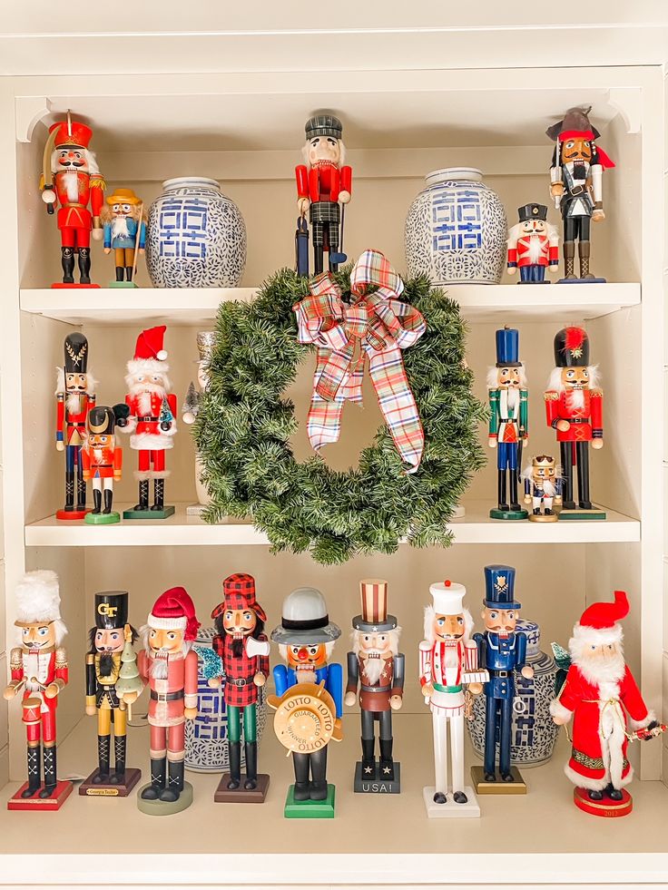 a christmas display with nutcrackers, wreath and figurines on shelves