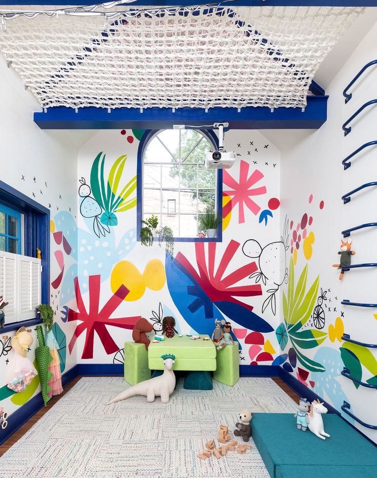 a room with colorful wallpaper and stuffed animals on the floor