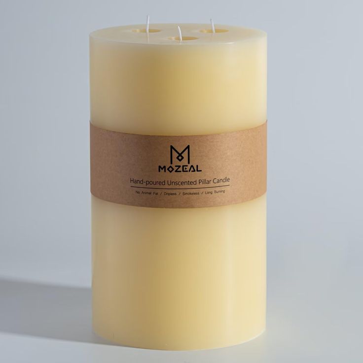 a white candle with a brown label on it