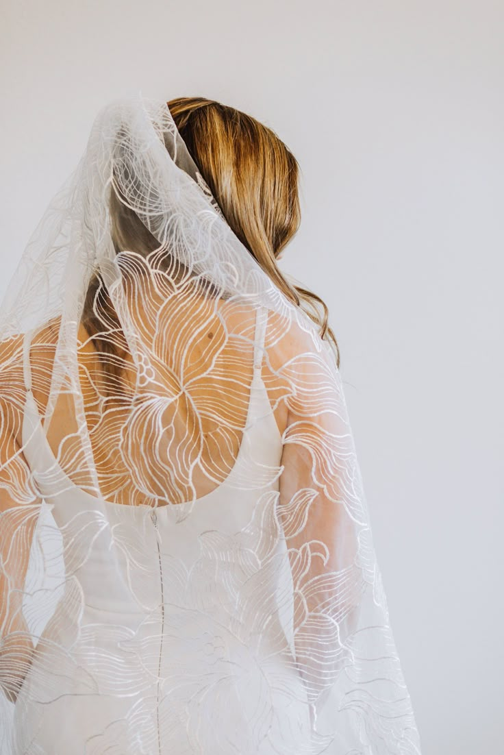 the back of a woman's wedding dress, with sheer white fabric on it