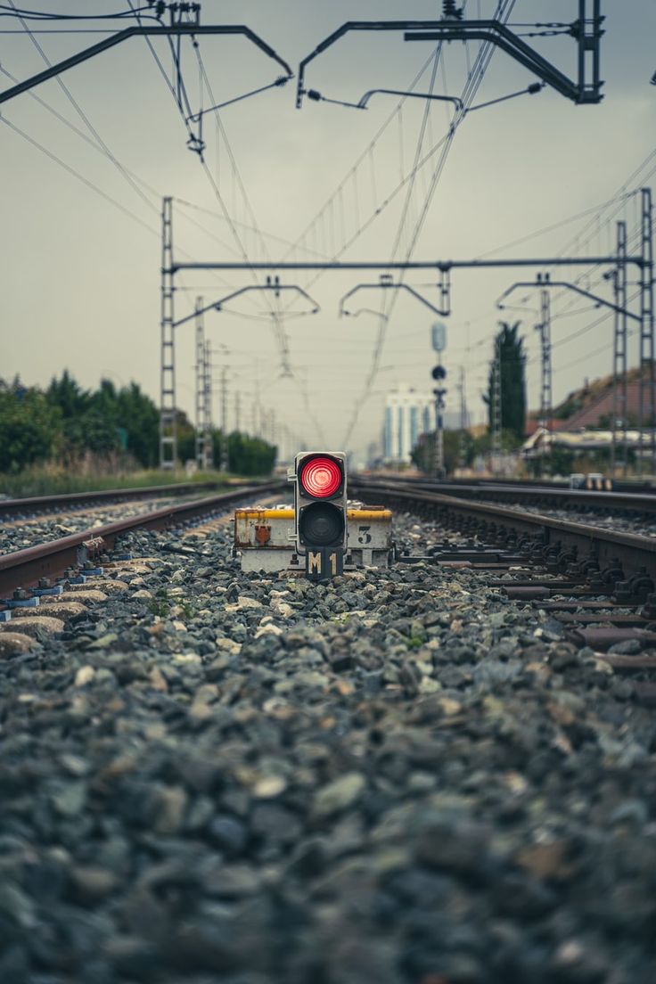 a red light sitting on the side of train tracks