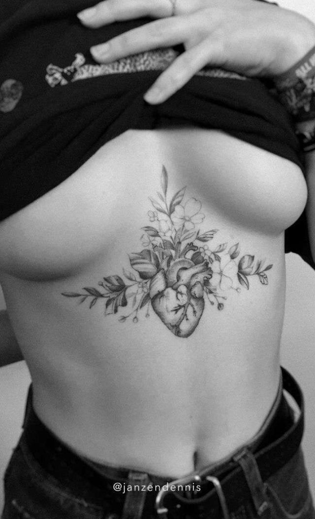 a woman's stomach with flowers and hearts tattooed on the side by tattoo artist