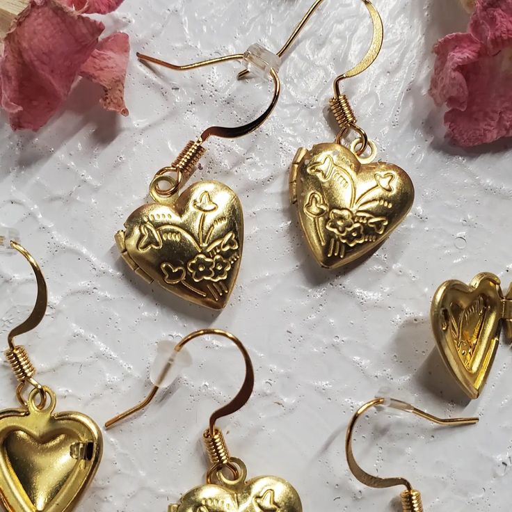 Elevate your style with our Gold Heart Locket Earrings, a delightful blend of charm and elegance. Each earring showcases a heart-shaped locket with an intricate floral design, infusing your look with a touch of romance and a delicate, feminine aesthetic. Crafted with nickel-free earring posts, these earrings prioritize comfort and safety, making them the perfect choice for any occasion. Embrace beauty and sophistication with these exquisite accessories. Wedding Open Heart Earrings For Pierced Ears, Gold Heart Earrings Gift For Her, Gold Heart Earrings As A Gift For Her, Gold Heart-shaped Earrings As Gift For Her, Gold Heart-shaped Earrings For Her, Metal Heart Earrings For Wedding, Dainty Metal Earrings For Valentine's Day, Metal Heart Earrings For Mother's Day, Gold Heart-shaped Drop Earrings For Her