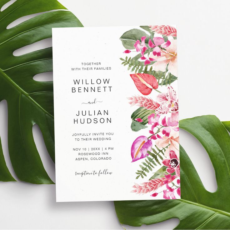 a wedding card with pink flowers and green leaves on the bottom, next to a palm leaf