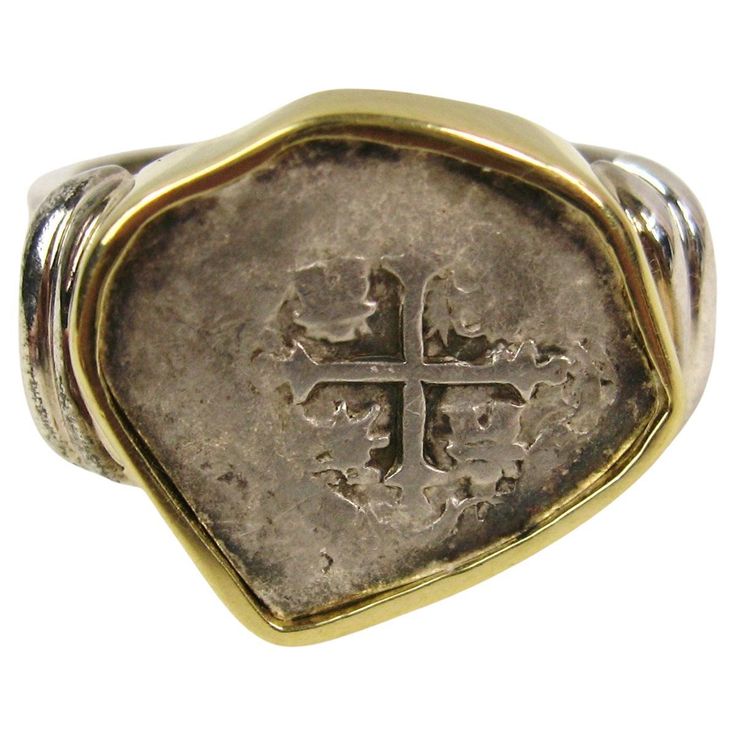 This stunning ring features a Spanish Cob Coin set in a beautiful combination of Sterling Silver and wrapped with 18 Karat Gold. The ring is a size 12, unisex design. The design is perfect for anyone who loves unique and historical pieces of jewelry. The coin, believed to have been minted in colonial Mexico, is a true conversation starter and will surely be a cherished addition to any jewelry collection. The ring is in excellent shape and ready to be worn with pride. Please be sure to check out Antique Collectible Coin Rings, Vintage Ceremonial Coin Necklaces, Classic Collectible Coin Rings, Antique Gold Coin-shaped Jewelry With Antique Finish, Antique Coin-shaped Sterling Silver Jewelry, Era Fashion, Coin Set, Coin Ring, Coin Jewelry