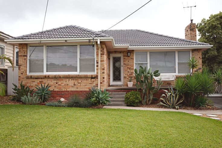 a brick house with green grass in front