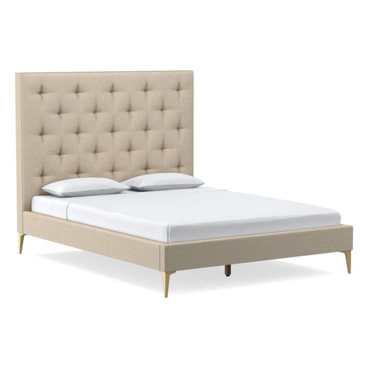 an upholstered bed with white sheets and beige headboard is shown in this image