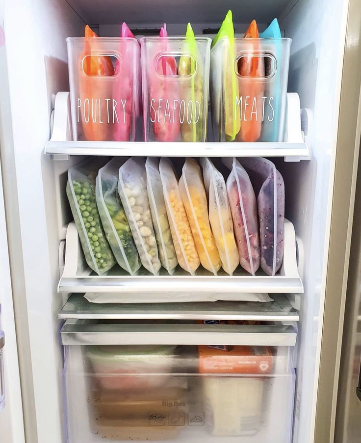 a refrigerator filled with lots of food and plastic containers on top of it's shelves