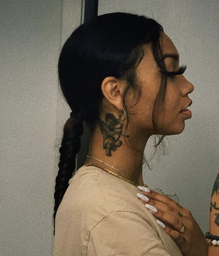 a woman with a tattoo on her neck looking into the distance while standing in front of a mirror