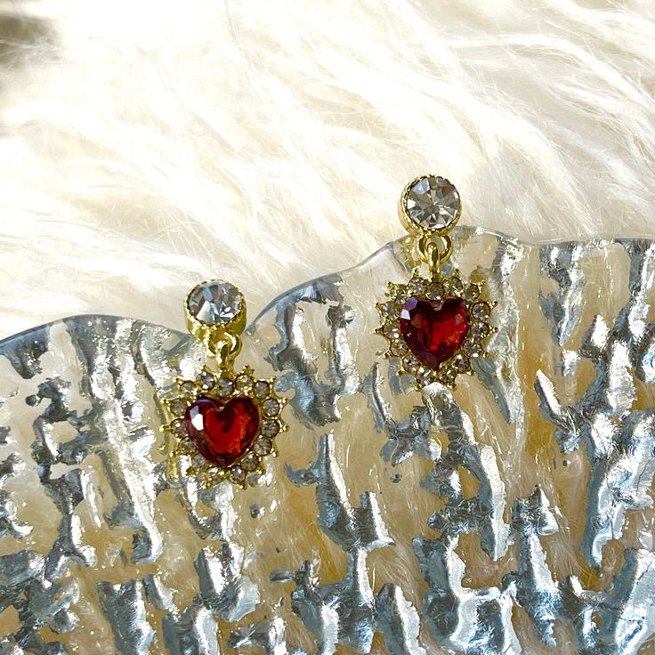 Absolutely stunning red heart ruby dangle drop stud earrings in 14K Gold filled finish, romantic heart shaped ruby birthstone dangle, with sparkly lace diamond cz stones surrounded. Beautiful burgundy gemstone gives classy, vintage and timeless glittery. It goes well with everyday/occasions/bridal or bridesmaid look, easily elevate your outfit. Also a perfect Valentine's Day/wedding bridesmaid bridal/birthday gifts idea to show your love! ♥ All of our jewelry are carefully handmade with delicate and exquisite details, all designed and made in Manhattan, New York. 💎 Features: ♥ Material: Finest 14K Gold Filled ♥ Main stone: Ruby Cubic Zirconia ♥ Side Stone: Cz crystal ♥ Push Back Closure 💎 Details: ♥ Approximate Measurements: - Length: 0.75" - Width: 0.45" ♥ Lightweight, easy to wear ♥ Ni Red Heart Pendant Earrings For Anniversary, Red Heart Earrings For Wedding, Ruby Earrings For Valentine's Day Anniversary, Ruby Earrings For Anniversary On Valentine's Day, Formal Heart Charm Earrings For Valentine's Day, Formal Double Heart Earrings For Valentine's Day, Red Heart Cut Elegant Earrings, Elegant Red Heart Cut Earrings, Red Dangle Heart Earrings For Anniversary