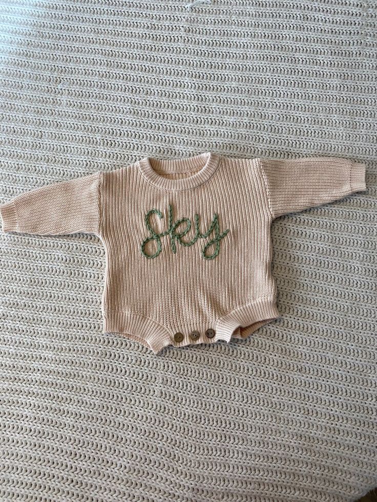 "Personalize this adorable sweater romper with your child's name! Each romper will be hand embroidered by me and is completely customizable. These rompers are oversized and great for years of wear.  Choose what color and size you want as well as the length of name you need. FLOWERS ARE NOT INCLUDED. They cost $3.50 each. You will need to add the \"add a flower\" listing into your cart along with the romper.   In the personalization box please put: 1. The word/words you would like 2. The color of yarn you would like. To ADD A FLOWER you need to purchase the \"Add Flower\" listing separately. There you can specify color and placement.  To ADD A DESIGN you will need to purchase the \"ADD a Design\" listing separately. Feel free to message me before you purchase so we can talk through the desi Winter Cotton Bubble Romper With Long Sleeves, Winter Long Sleeve Cotton Bubble Romper, Fall Long Sleeve Bubble Romper For Playtime, Long Sleeve Cotton Bubble Romper, Winter Knitted Long Sleeve Onesie, Cute Long Sleeve Cream Bubble Romper, Winter Long Sleeve Bubble Romper For Playtime, Casual Long Sleeve Cream Onesie, Cream Long Sleeve Onesie For Fall