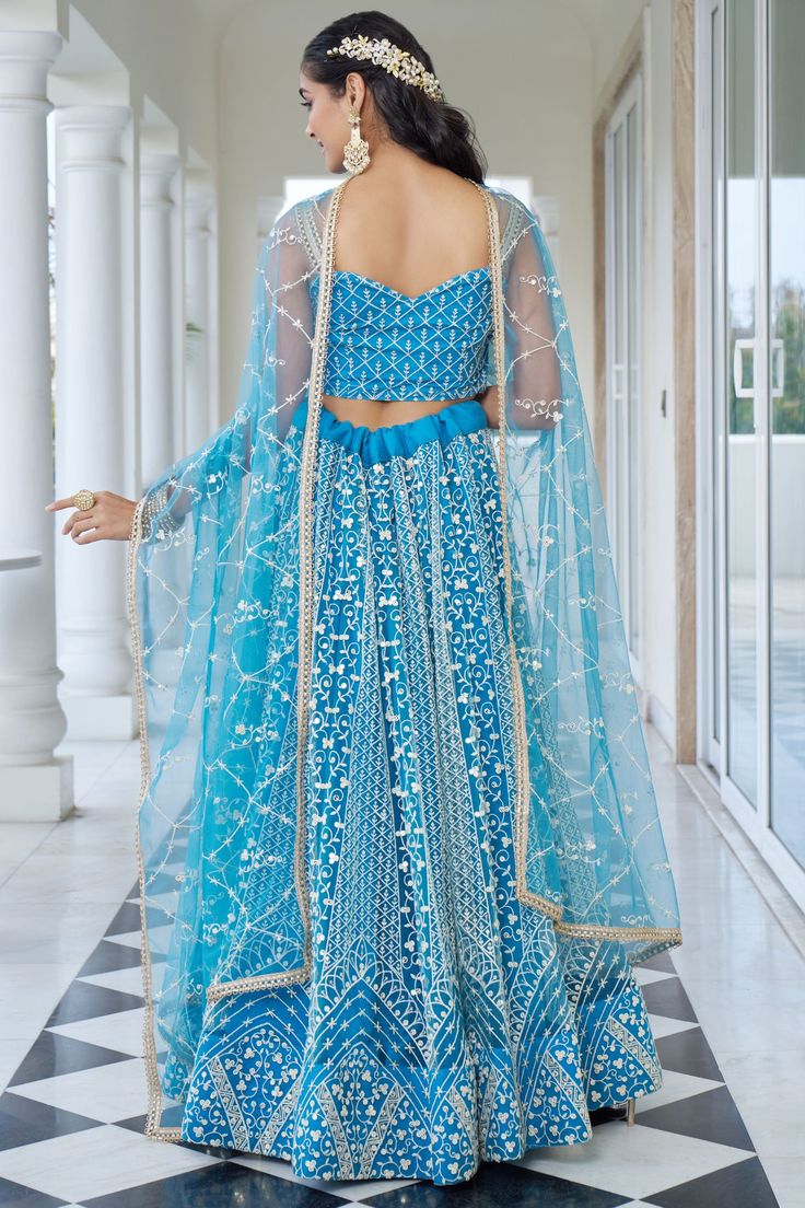 Elevate your Sangeet style with our exquisite Designer Lehenga. Crafted from premium net fabric, it features intricate sequins embroidery that catches every light, ensuring you dazzle throughout the night. Anarkali Set For Reception During Navratri, Traditional Net Dresses With Mirror Work, Party Wear Sets With Mirror Work On Net, Traditional Sets With Mirror Work And Net Material, Party Wear Net Sharara With Mirror Work, Semi-stitched Net Sharara With Mirror Work, Embroidered Net Dress With Traditional Drape, Fitted Anarkali Net Choli, Fitted Net Sharara With Intricate Embroidery