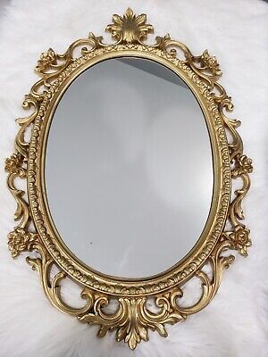 an ornate gold framed mirror on a white fur