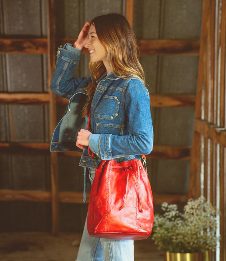 Everything and the kitchen sink (ok, not quite) can fit inside EVE.  EVE is a new bucket-style bag with a drawstring cinch top, wide flat bottom, and an adjustable and removable crossbody strap.  As tall as she is cute, EVE has a cool football topstitch effect up the front seams.  Inside find a zip pocket, two slip pockets and a key FOB.  Roomy and great for errands, EVE is the timeless silhouette youve been looking for. Casual Bucket Bag With Zipper Pocket, Casual Bucket Bag Tote With Zipper Pocket, Red Hobo Bag For Fall Travel, Casual Bucket Satchel For On-the-go, Fall Travel Red Hobo Bag, Everyday Use Bucket Bag With Pockets, Casual Crossbody Bucket Bag With Zipper Pocket, Weekend Shoulder Bag With Detachable Strap, Zipper Pocket Shoulder Bucket Bag