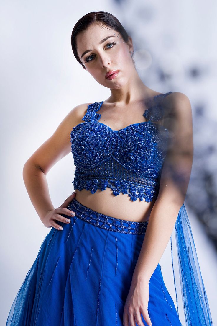 Blue skirt with crystal embellished stripes. Paired with floral embellished draped blouse.
Component: 2
Pattern: Embellished
Type Of Work: Floral, crystal
Neckline: Sweetheart
Sleeve Type: Sleeveless
Fabric: Swiss net
Color: Blue
Other Details: 
Attached drape
Occasion: Destination Wedding - Aza Fashions Glamorous Blue Embellished Sets, Party Choli With Intricate Embroidery, Party Wear Embellished Top With Traditional Drape, Blue Hand Embellished Choli For Party, Blue Embellished Party Wear Sets, Glamorous Festive Georgette Tops, Blue Hand Embellished Choli With Traditional Drape, Hand Embellished Fitted Choli With Traditional Drape, Hand Embellished Blue Choli With Traditional Drape