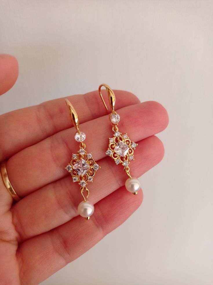 These pearl dangle earrings for brides are perfect for a bling wedding theme. Gorgeous pearl bridal earrings with beautiful pearls in unique design. It looks beautiful and attractive. You will love it.  Available: gold with ivory or white pearls  Please read my policies before purchase: https://www.etsy.com/shop/SilkPearlDesign#policies Elegant Pearl Drop Earrings For Wedding, Elegant Gold Dangle Bridal Earrings, Elegant Gold Plated Crystal Earrings, Graceful Gold Dangle Earrings, Classic Gold Bridal Earrings With Elegant Design, Pearl Embellished Cubic Zirconia Wedding Earrings, Elegant Gold Plated Dangle Pearl Earrings, Pearl White Pearl Clip-on Earrings For Wedding, Gold Dangle Chandelier Earrings For Wedding