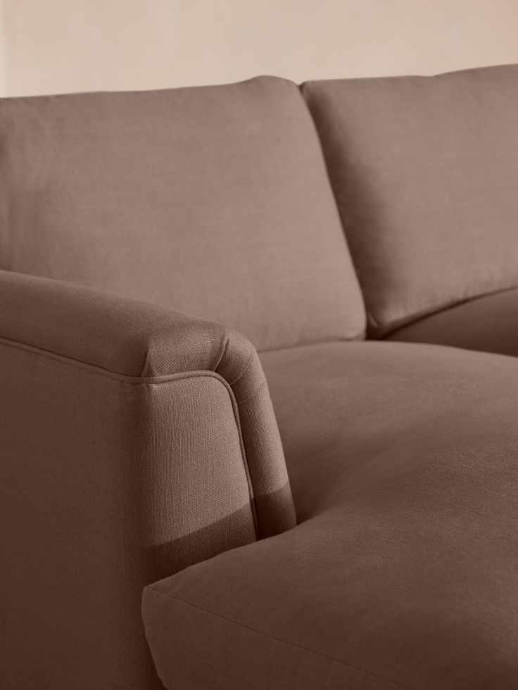 a brown couch sitting in front of a white wall