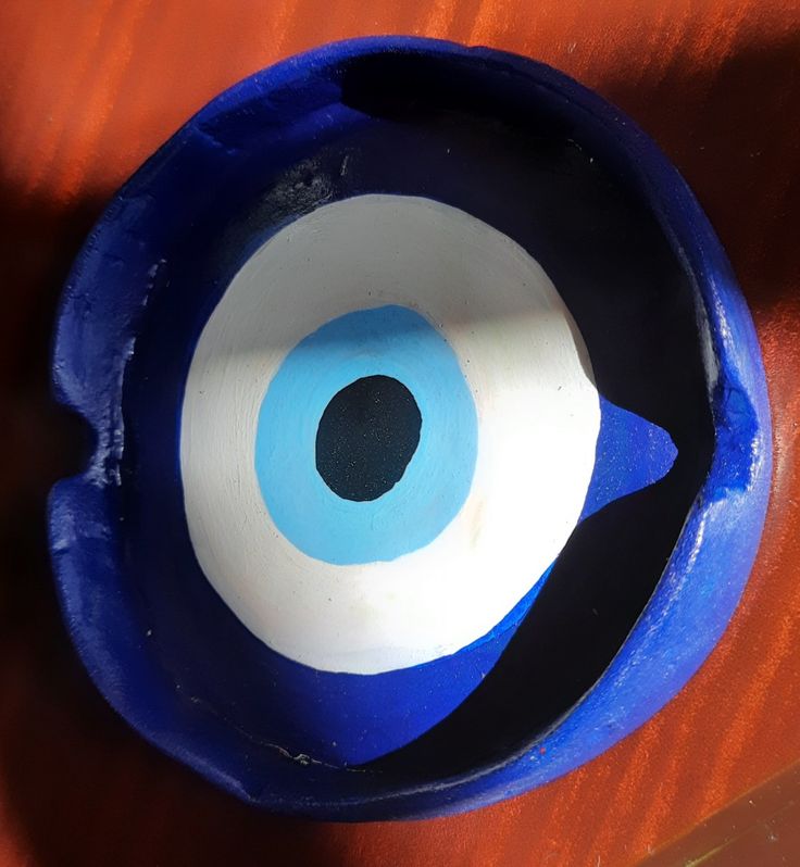 a blue bowl with an evil eye painted on it