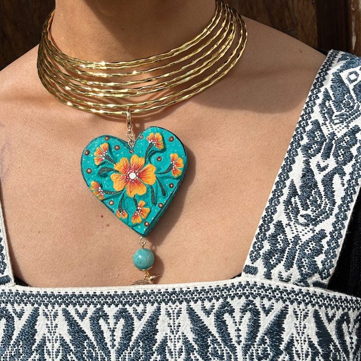 We combine art and elegance to create this beautiful piece. Our handmade necklaces will be the perfect element to make your outfit standout. You could have the entire collection or gift them to someone special.  Material: Real Gold plate brass, copal wood Dimensions: heart 6cm, charm length 11cm Features : Lightweight, Unique and Simple design The Talavera of Puebla is part of the intangible heritage of humanity, declared by UNESCO. It is a type of majolica ceramic with a mixture of Chinese, Italian, Spanish, and indigenous techniques, and its colors are obtained from natural pigments. Its main characteristics are its vitreous finish and the use of bulky cobalt blue, this made it even more exclusive and ostentatious than Spanish craftsmanship. Its production requires at least 120 hours of Unique Clavicle Chain Choker, Artisan Gold Heart-shaped Jewelry, Handmade Heart-shaped Jewelry For Festivals, Unique Clavicle Chain Choker For Festivals, Handmade Brass Heart Pendant Jewelry, Unique Festival Pendant Choker, Unique Clavicle Chain Choker For Gift, Unique Pendant Choker For Festivals, Unique Gold Heart-shaped Jewelry