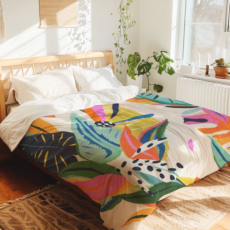 a bed with a colorful comforter on top of it next to a potted plant