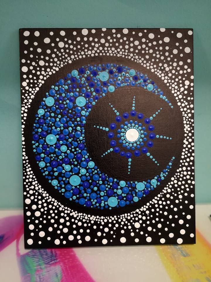 a blue and black painting on a white surface with polka dot dots in the center