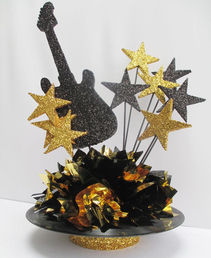 a black and gold guitar centerpiece with stars on it